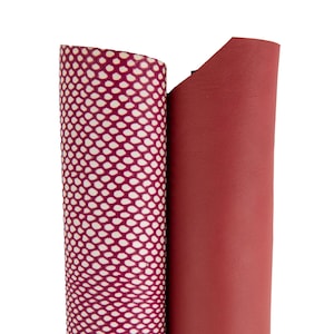 Peut inclure: Deux rouleaux de cuir bordeaux, l'un avec un motif de filet blanc.