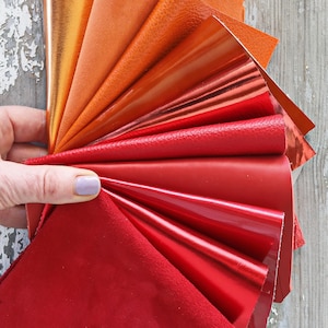 Ritagli di pelle ROSSO e ARANCIO, selezione casuale, scampoli laminati e non, tinta unita, LISCI, grana e morbidezze varie  300 gr   B1519