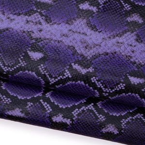 May include: Close-up of a textured material with a snakeskin pattern. The design features shades of purple and black, creating a visually striking and detailed surface. The pattern is consistent throughout the material.