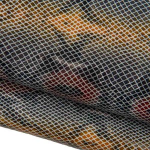 May include: A piece of fabric featuring a repeating grid pattern in white over a multi-colored background of orange, brown, and dark blue tones. The material has a smooth, slightly reflective surface with visible folds creating depth and texture.
