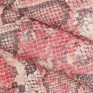Peut inclure: Gros plan sur un tissu textur&eacute; avec un motif peau de serpent. Le motif pr&eacute;sente un motif carr&eacute; r&eacute;p&eacute;titif dans des tons de rouge, de rose et de marron fonc&eacute;, cr&eacute;ant une texture semblable &agrave; celle d'un reptile. Le tissu est pli&eacute;, montrant profondeur et dimension.
