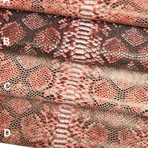 Puede incluir: Cuatro piezas de tela de piel de serpiente roja, negra y blanca con un patrón texturizado. La tela está doblada en capas, con la capa superior etiquetada como "A", la segunda capa etiquetada como "B", la tercera capa etiquetada como "C" y la capa inferior etiquetada como "D".