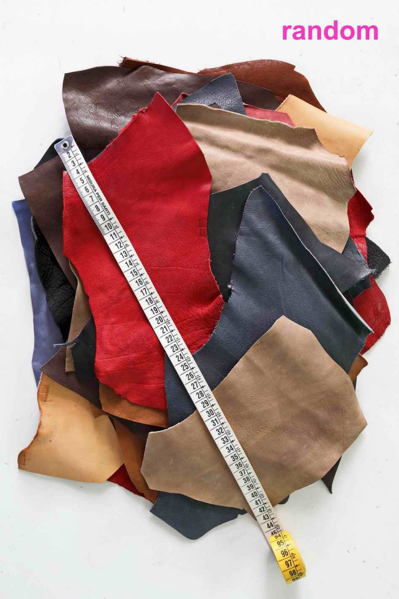Pode incluir: Um monte de sobras de couro em v&aacute;rias cores, incluindo vermelho, marrom, bege e azul. Uma fita m&eacute;trica est&aacute; sobre o couro.