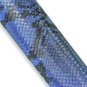 Op de afbeelding: Een rol blauwe stof met een slangenpatroon. De stof heeft een glanzend, gestructureerd oppervlak met tinten blauw, zwart en zilver. Het woord "Blu" is linksonder zichtbaar.