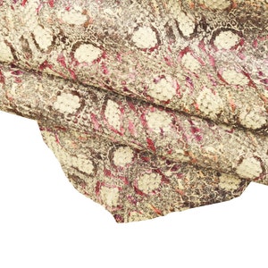 May include: Close-up of a textured leather material with a snakeskin pattern. The leather features a mix of cream, brown, and pink hues, with the word "rosa" at the bottom.