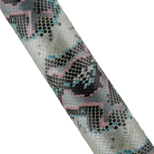 Op de afbeelding: Close-up van een gedeelte van een stof met patroon met een slangenleerontwerp. Het patroon heeft een mix van grijs, zwart, roze en teal kleuren. De stof lijkt getextureerd en heeft een lichte glans.