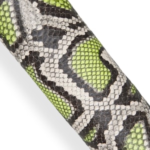 Peut inclure: Gros plan sur une surface texturée avec un motif peau de serpent. Le motif présente un motif répétitif d'écailles noires, blanches et vert néon. Le matériau semble enroulé autour d'une forme cylindrique.
