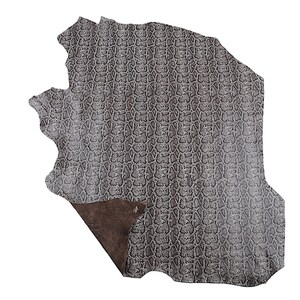May include: A piece of grey leather with a snakeskin pattern. The leather has a textured surface and a dark brown underside. The edges of the leather are uneven, giving it a natural look. The leather is likely used for crafting.