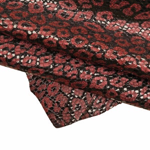 May include: Red and black fabric with a glittery snakeskin pattern.
