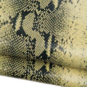 Può includere: Primo piano di un materiale in pelle strutturato con un motivo a pelle di serpente. Il design presenta un mix di scaglie nere e giallo-verdi. Il testo "Verde giallastro" è in basso.