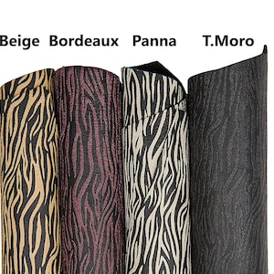 Puede incluir: Cuatro rollos de tela con diseño de rayas de cebra en beige, burdeos, blanco roto y negro. La tela está enrollada firmemente y los nombres de los colores están impresos encima de los rollos. Ideal para proyectos de manualidades.