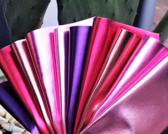 May include: A collection of metallic pink and purple fabric swatches. The fabric has a shiny, iridescent finish.