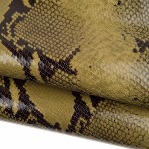 Könnte beinhalten: Nahaufnahme eines strukturierten Schlangenhautmusters. Das Muster weist eine Mischung aus olivgrünen und dunkelbraunen Schuppen auf, die ein reptilienartiges Aussehen erzeugen. Die Schuppen haben eine subtile, gitterartige Textur.