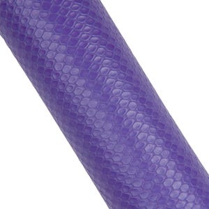 Puede incluir: Una esterilla de yoga enrollada en un vibrante tono púrpura. La superficie de la esterilla presenta un patrón texturizado en forma de escamas, que proporciona agarre e interés visual. La imagen es un primer plano, destacando los detalles y el color del material.