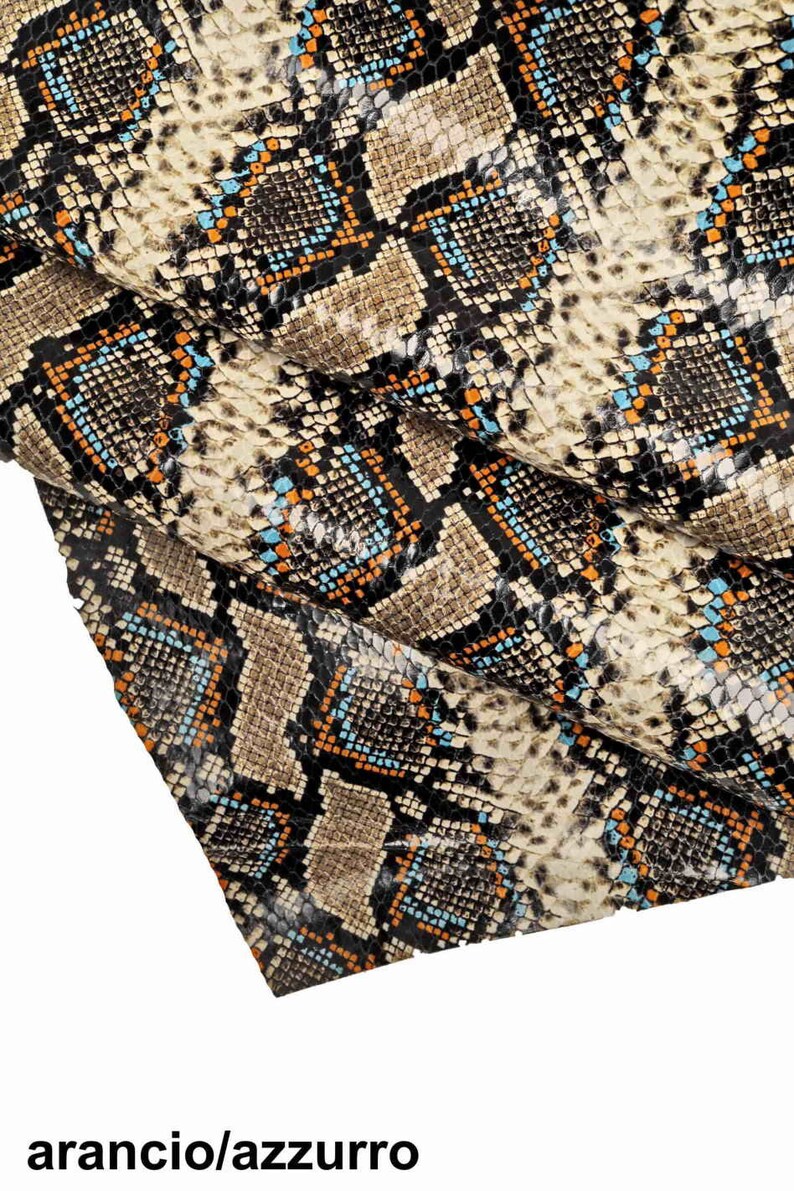 Pode incluir: Close-up de um tecido de pele de cobra com um padr&atilde;o preto, marrom, laranja e azul.