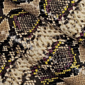 Pode incluir: Close-up de um tecido de pele de cobra com um padr&atilde;o de quadrados pretos, marrons, amarelos e roxos.