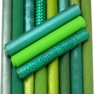 Op de afbeelding: Een verzameling van twaalf cilindrische rollen kunstleer in diverse tinten groen. De texturen omvatten gladde matte, metallic, slangenleer- en geometrische patronen, gerangschikt in een verticaal raster met drie rollen horizontaal geplaatst.