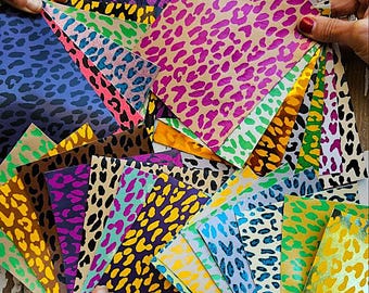 May include: A collection of colourful leopard print patterned paper sheets in various colours, including pink, yellow, blue, green, and brown.