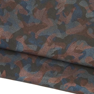 Könnte beinhalten: Nahaufnahme eines Stoffes mit Camouflagemuster. Das Design zeigt eine Mischung aus dunkelblauen, braunen und grauen Formen auf schwarzem Hintergrund. Der Stoff ist gefaltet und zeigt seine Textur und sein Muster.