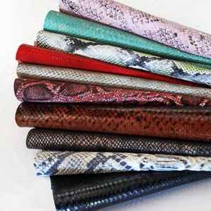 Peut inclure: Une collection de feuilles de simili cuir roul&eacute;es de diff&eacute;rentes couleurs et motifs peau de serpent. Les couleurs incluent le rose, le sarcelle, le rouge, l'argent, le marron, le noir, etc. Le texte "the picture is an example" est en bas.