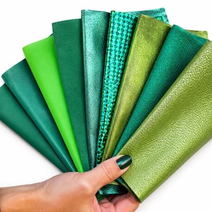 Op de afbeelding: Een waaier van acht leren stalen in verschillende tinten groen, variërend van diep bosgroen tot helder limoengroen. De texturen omvatten gladde matte afwerkingen, metallic glans en een geometrisch rasterpatroon, allemaal in een waaier gerangschikt.
