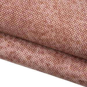 Puede incluir: Primer plano de un material texturizado de color marrón rojizo con un patrón similar a escamas. La tela parece estar doblada, revelando un color más claro, blanquecino debajo. El diseño se asemeja a la piel de reptil.