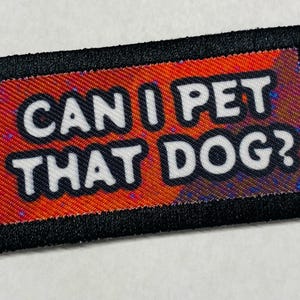 May include: A black and orange patch with the text "Can I pet that dog?" in white letters.