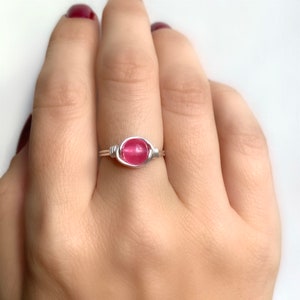 K&ouml;nnte beinhalten: Ein Ring aus Silberdraht mit einem rosafarbenen Edelstein.