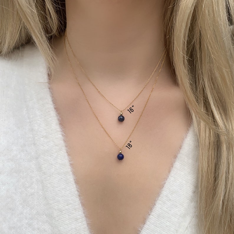 May include: Two gold necklaces with blue gemstone pendants. The top necklace is 16 inches long and the bottom necklace is 18 inches long.