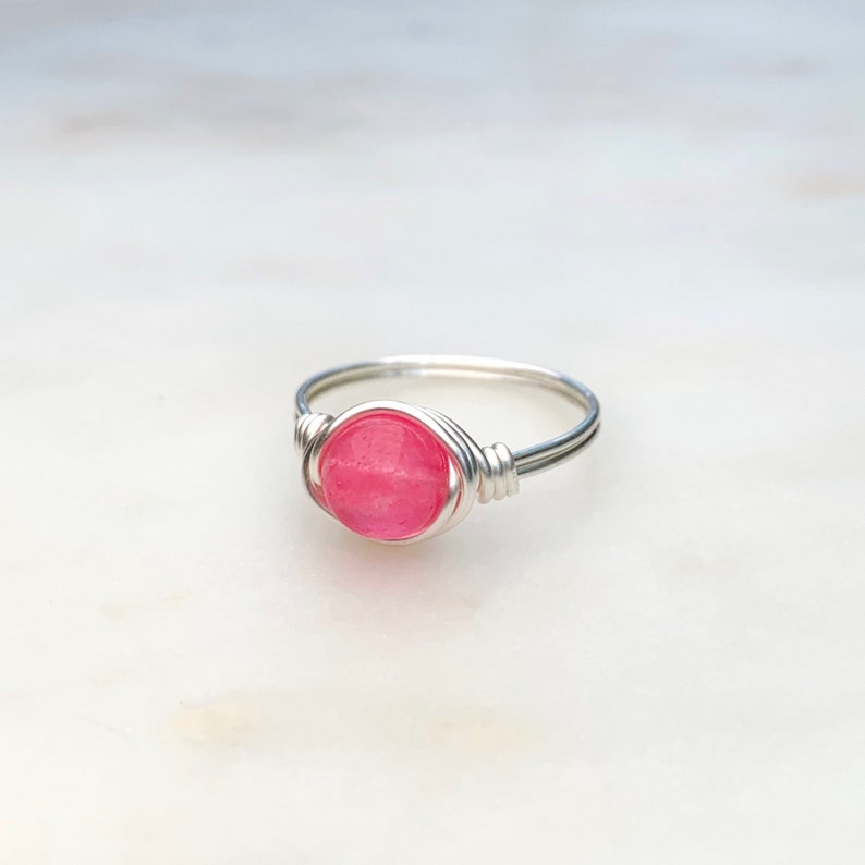 K&ouml;nnte beinhalten: Ein Ring aus Silberdraht mit einem rosafarbenen Edelstein.