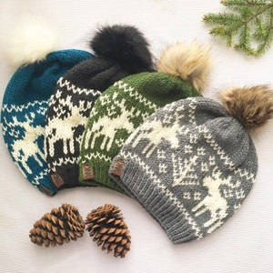 Peut inclure: Quatre bonnets d'hiver en tricot avec des pompons en fausse fourrure. Les bonnets présentent un motif de renne blanc sur fond turquoise, noir, vert et gris.
