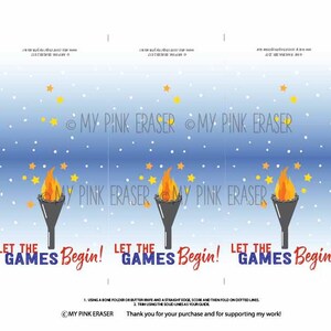 Puede incluir: Un dise&ntilde;o imprimible con fondo azul, estrellas amarillas y puntos blancos. Presenta tres antorchas con llamas y el texto "LET THE GAMES Begin!". El dise&ntilde;o incluye l&iacute;neas punteadas para plegar.