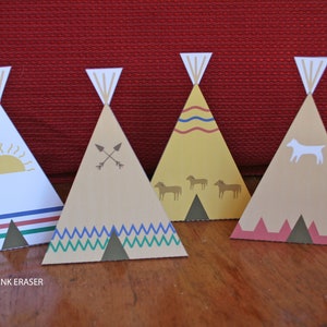 May include: Five paper teepee party decorations with different designs. The teepees are brown, yellow, and white with various patterns and designs, including a sun, arrows, horses, and a dog.