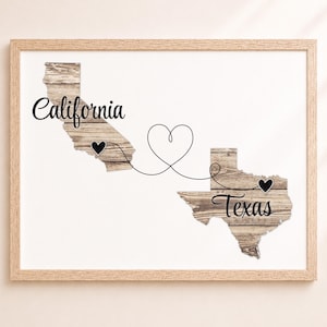 May include: A framed wall art print featuring the states of California and Texas with a rustic wood grain texture. A thin black line connects the two states with a heart shape in the center and small black hearts marking locations within each state.