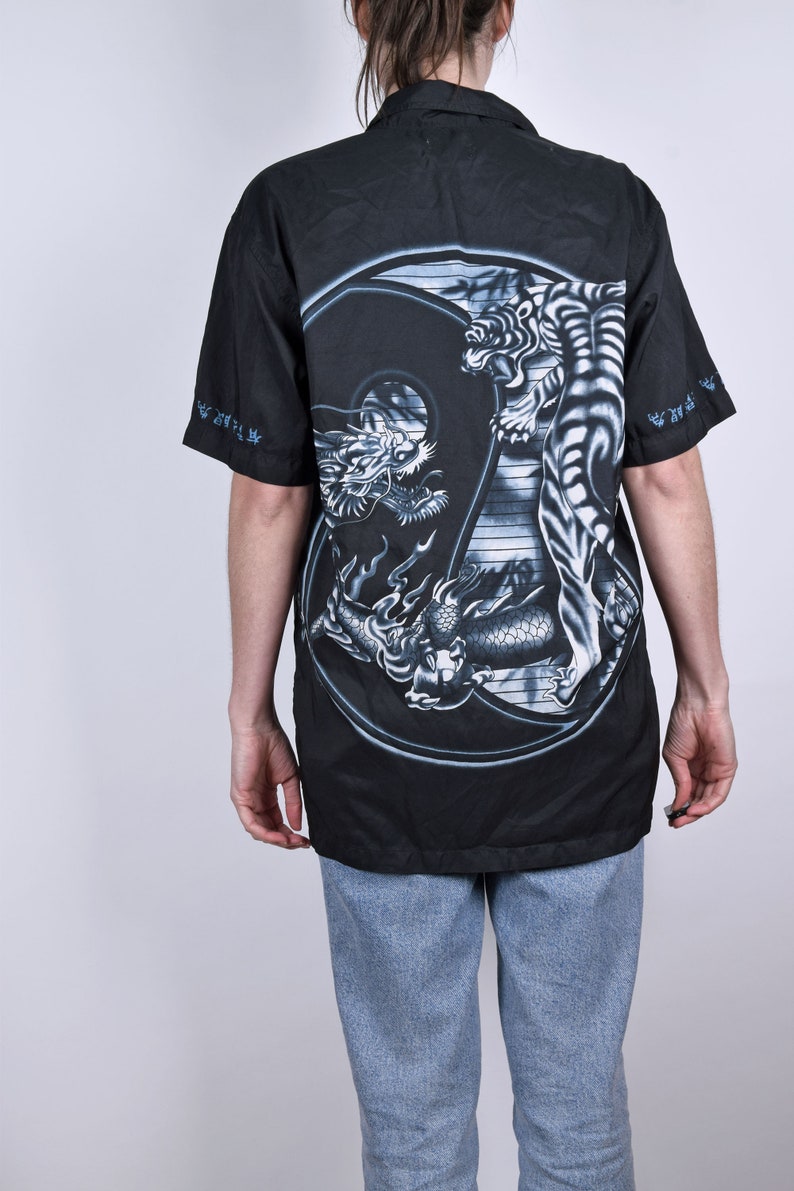 May include: Black button-up shirt with a large yin-yang design featuring a dragon and a tiger in gray and white on the back.