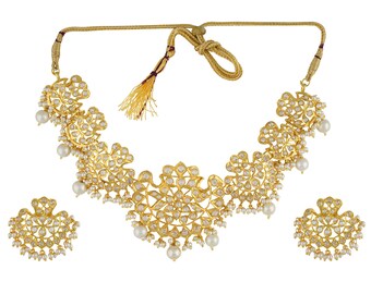 May include: A gold-toned necklace and earring set. The necklace features a floral design with small white stones and dangling pearls. The matching earrings have a similar design. The set is displayed on a white background.