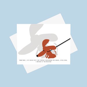 May include: A greeting card with a cartoon illustration of a dachshund dog on a leash. The text on the card reads "Sometimes, life can be just like taking a dachshund for a walk, a real drag. I am here if you need me!"