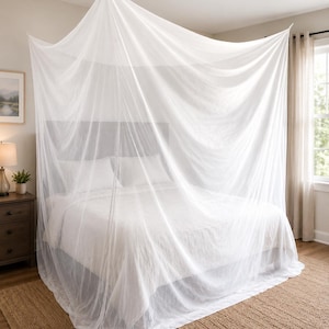 May include: A white, sheer, rectangular bed canopy made of fine mesh netting. The canopy is suspended from the ceiling, draping over a bed to create a full enclosure. The lightweight fabric hangs in soft, vertical folds around the mattress.