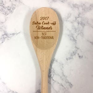 May include: A wooden cooking spoon with the text "2017 Salsa Cook-off Winner Best Non-Traditional" engraved on it.