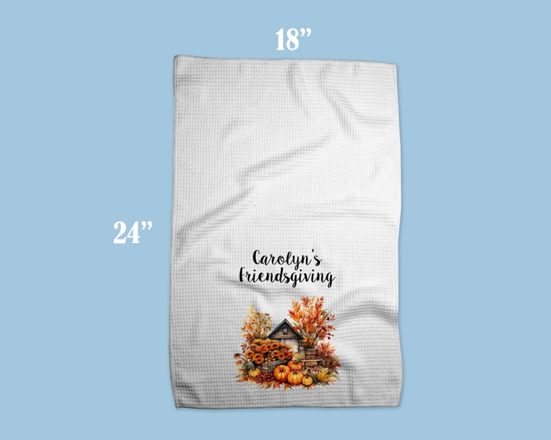 Puede incluir: Toalla de cocina blanca con un dise&ntilde;o de oto&ntilde;o que presenta una peque&ntilde;a casa, calabazas y hojas. El texto "Carolyn's Friendsgiving" est&aacute; impreso en la toalla. La toalla mide 45,7 cm por 61 cm.