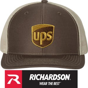 May include: Brown and tan trucker hat with the UPS logo embroidered on the front. The hat features a curved brim and a mesh back. The Richardson logo is displayed at the bottom.