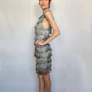 a woman in a dress standing in front of a white backdrop