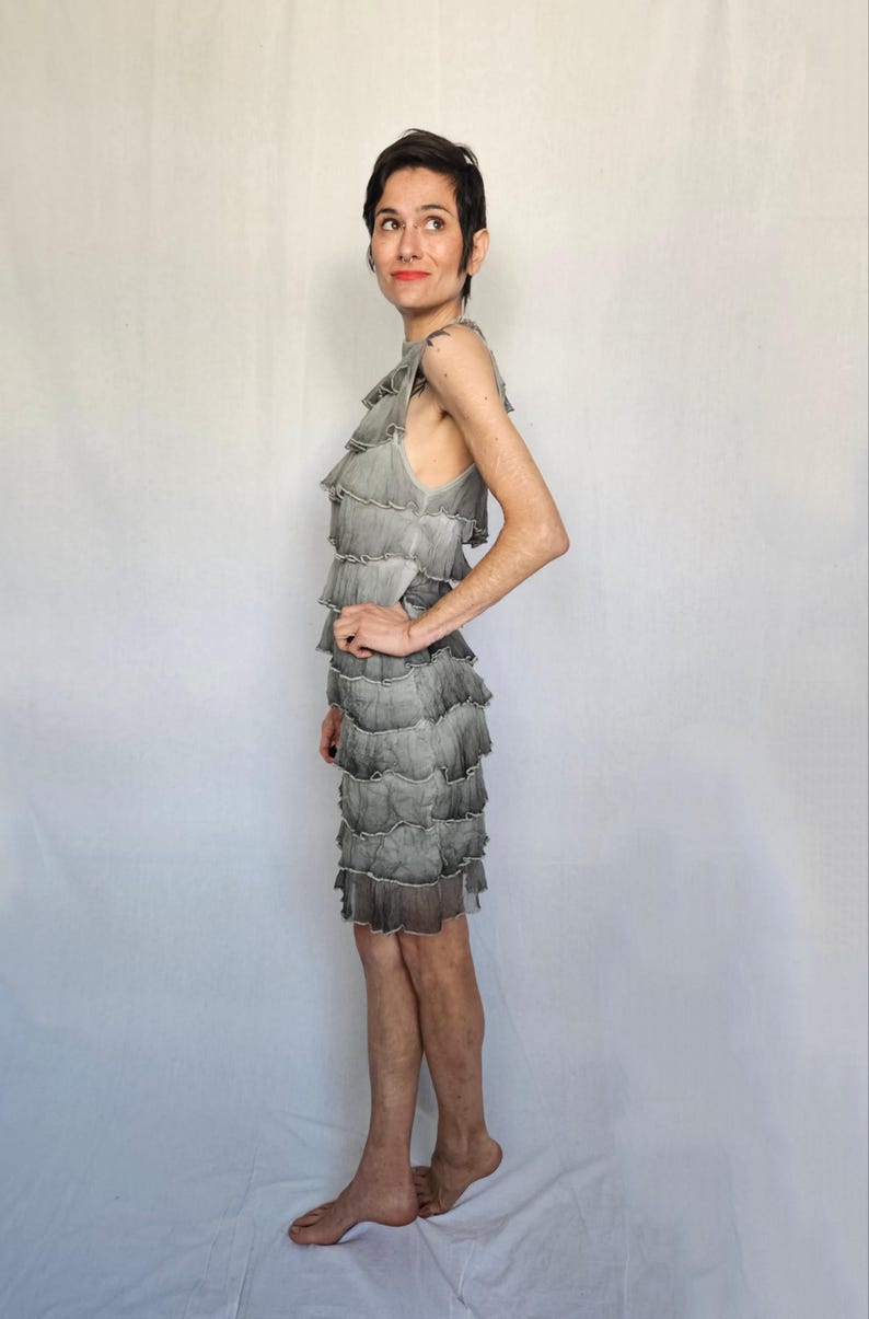 a woman in a dress standing in front of a white backdrop