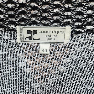 May include: Black and white knit sweater with a black label that reads "Courr&egrave;ges and co paris" and "Made in Italy". The label also has a size tag that reads "40".