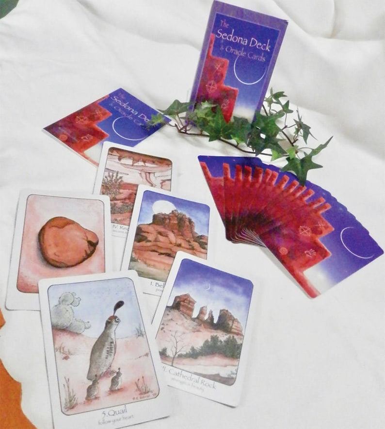 May include: A set of oracle cards with purple and red backgrounds. The cards feature images of landscapes and animals. The cards are titled "The Sedona Deck Oracle Cards".