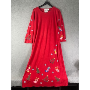 May include: A long, red Christmas dress with long sleeves. The dress is adorned with embroidered Christmas trees, stockings, and ornaments. The dress is hanging on a black hanger against a neutral background.
