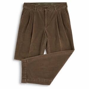 Puede incluir: Pantalones marrones con frente plisado, cierre de botón y cremallera, trabillas para cinturón y dobladillos con vuelta. La etiqueta interior de la cintura muestra el texto SAVANE. Estos pantalones están hechos de tela texturizada y tienen bolsillos laterales.
