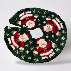 May include: A green Christmas tree skirt with a circular design and a cutout for the tree trunk. The skirt features four Santa Claus figures in red suits with white trim and snowflake accents.