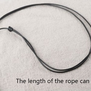 May include: A black adjustable cord necklace with a sliding knot. The length of the rope can be adjusted.