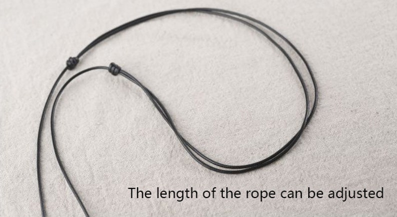 May include: A black adjustable cord necklace with a sliding knot. The length of the rope can be adjusted.